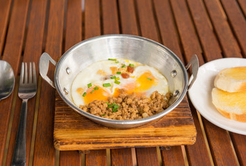Morning Tasty Breakfast at Cafe. Fried eggs, pork and toasts on a plate. Wood table, closeup.