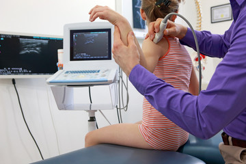 caucasian girl's arm diagnosis carried out with the use of an ultrasound