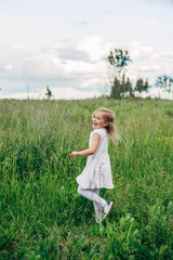 Child runs and jumps on a path in the field
