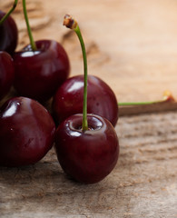 Ripe, sweet cherries on an old wooden background.