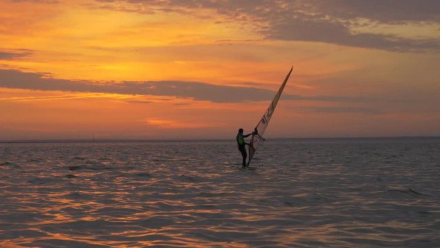 Beginner windsurfer learns balancing on sailboard