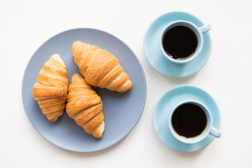 cup of coffee with croissant on white background
