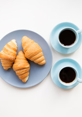 cup of coffee with croissant on white background