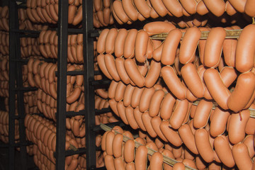 Sticks salami or sausages hanging on the ropes in the refrigerator. Production and sales of sausages.