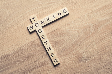 Working together words collected of game cubes on wooden surface