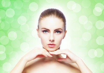 Naklejka premium Portrait of young, beautiful and healthy woman: over green background. Healthcare, spa, makeup and face lifting concept.