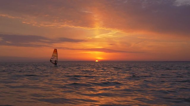 Windsurf sailing at great view of sunrise