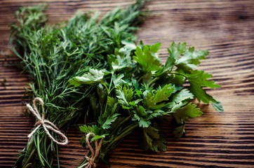 Fresh green dill and parsley herbs on rustic wooden table. Top view with copy space