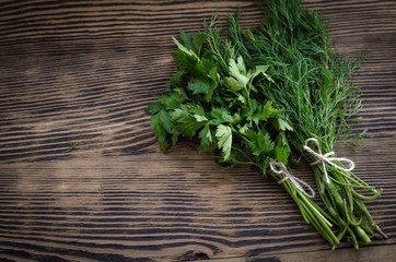 Fresh green dill and parsley herbs on rustic wooden table. Top view with copy space