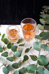 eucalyptus branches on an old table with a glass of rose wine
