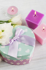 Obraz na płótnie Canvas Arrangement of candles, flowers, pastel gift box