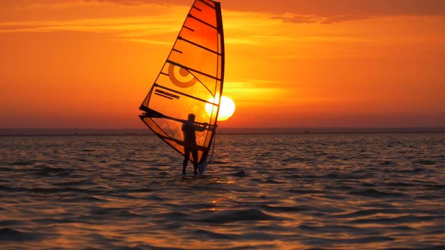 Sun shines through sail of windsurf