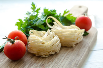 Ingredients for cooking Italian pasta - spaghetti, tomatoes, basil and garlic.