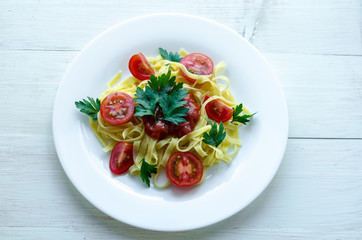 Tagliatelle pasta with tomato sauce decorated with basil leafs