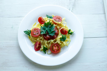 Tagliatelle pasta with tomato sauce decorated with basil leafs