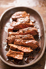 Sliced angus steak on iron cast with salt and pepper and juices 