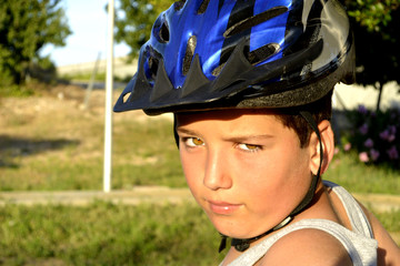 A boy with helmet is riding a Monowheel - mono scooter in the park © Olga
