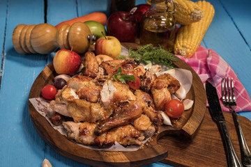 Whole roasted chicken with vegetables, on wooden table,