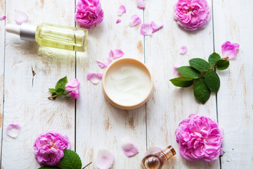 cosmetic creams and rose essence oil with rose petals on white background Spa treatment. Spa massage