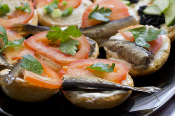 Sandwiches with sprats and tomatoes