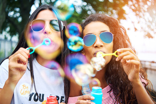 Two girls blowing bubbles 