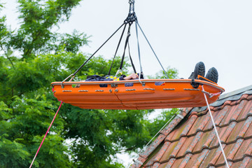 Eine verletzte Person wird Spezialtechnik von dem Dach eines Hauses gerettet