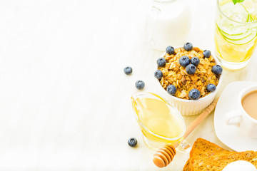 Healthy breakfast with granola, honey and milk on white background with copy space