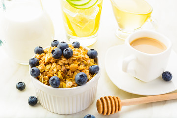 Granola with blueberry, honey and milk for healthy breakfast and coffee