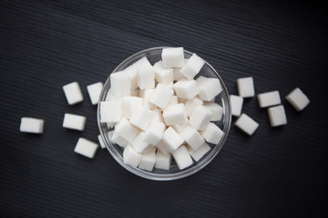 White sugar cubes in center of black background