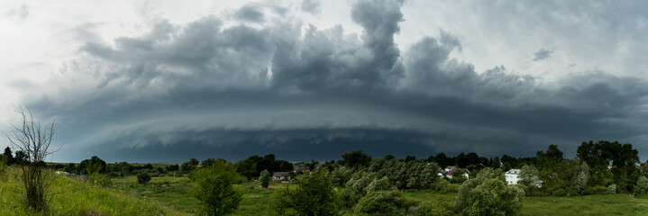 Supercell thunderstorm in the village, panorama of the storm clouds