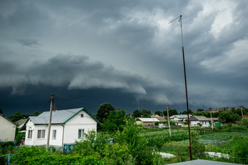 Approaching supercell thunderstorm in the village, squall line, storm clouds