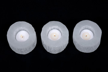 White selenite cylinder tea light holder on black background