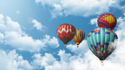 Naklejka premium Mehrere Heißluftballons fliegen vor einem blauen bewölkten Himmel bei Sonnenuntergang