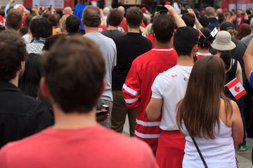 Canada Day celebrations in Trafalgar Square London 2017 with happy crowds enjoying the festival atmosphere, music and beer, singing the national anthem and waving Canadian flags.