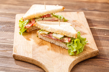 Fresh sandwiches on wooden board
