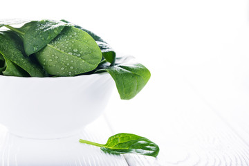 Fresh raw spinach in white bowl