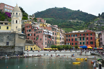 VERNAZZA, ITALY - JUNE 14, 2017: harbor of Vernazza with the church of Santa Margherita and its colorful houses in Italian Riviera, Cinque Terre, Italy
