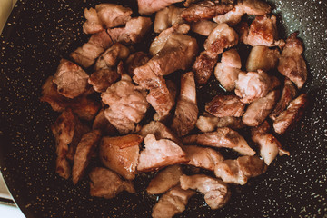Food ingridients: meat, onion, ginger for recipe stewed beans with meat frying in a pen on a stove. Steps in cooking, process of preparing food. Concept of homemade healthy food.