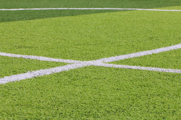 Obraz premium Photo of a green synthetic grass sports field with white line shot from above.