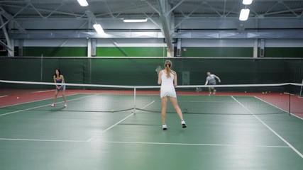 Two teams playing tennis in double game. Women and men players practicing - Powered by Adobe