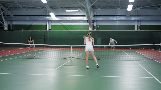 Two teams playing tennis in double game. Women and men players practicing
