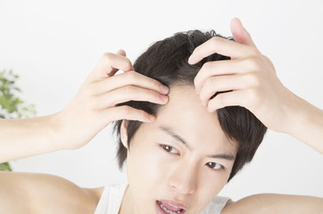 Fototapeta premium ネガティブメンズビューティ 額の生え際を見て困るイメージ