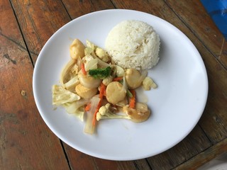 fried tofu with vegetables in white dish with thai jasmine rice on wooden background. Thai style Food. Vegetarian Food.