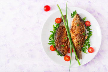 Fried fish carp and fresh vegetable salad. Flat lay. Top view
