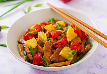 Veal fillet - stir fry with oranges and paprika in sweet and sour sauce on a light background
