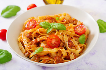 Pasta Fettuccine Bolognese with tomato sauce in white bowl.