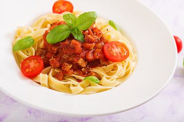 Pasta Fettuccine Bolognese with tomato sauce in white bowl.