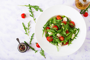 Vitamin Salad of fresh tomatoes, arugula, feta cheese and peppers. Dietary menu. Proper nutrition. Top view. Flat lay.