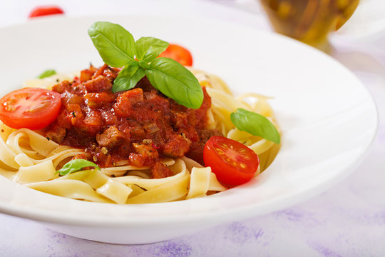 Pasta Fettuccine Bolognese with tomato sauce in white bowl.