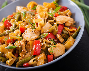 Stir Fry from chicken fillet, green beans and paprika with pasta in the form of heart